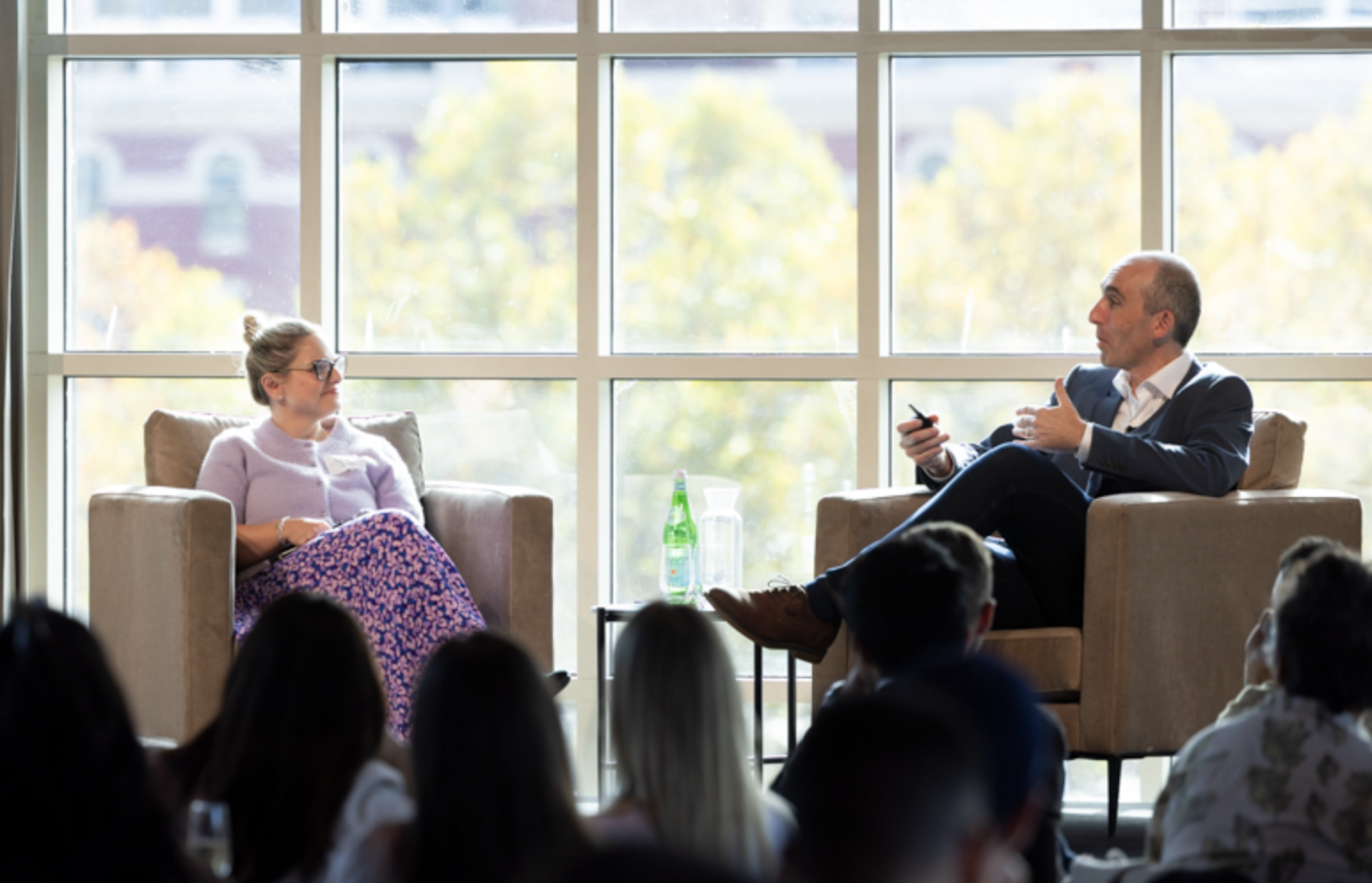 a man and a woman are sitting in front of a large window
