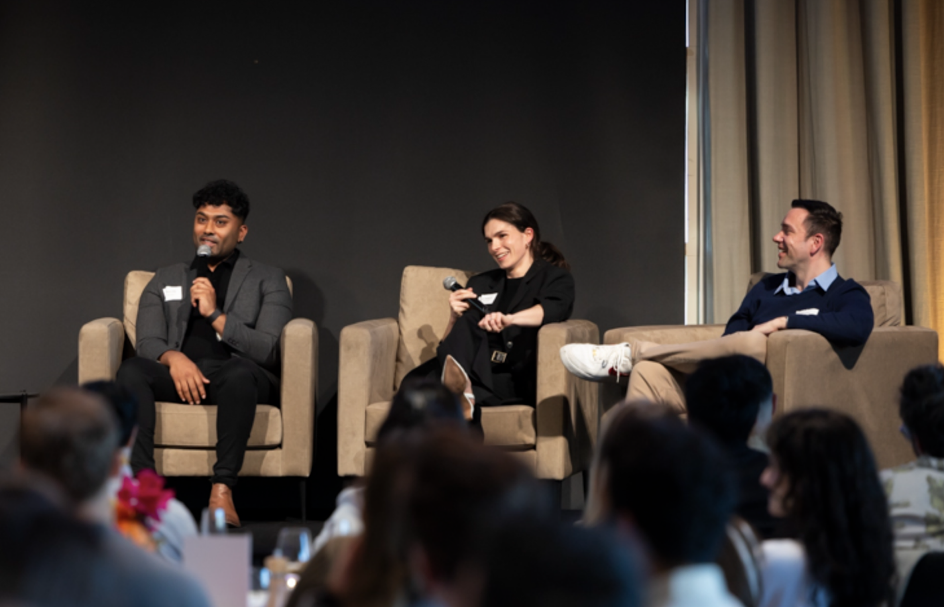 A panel of three people on stage