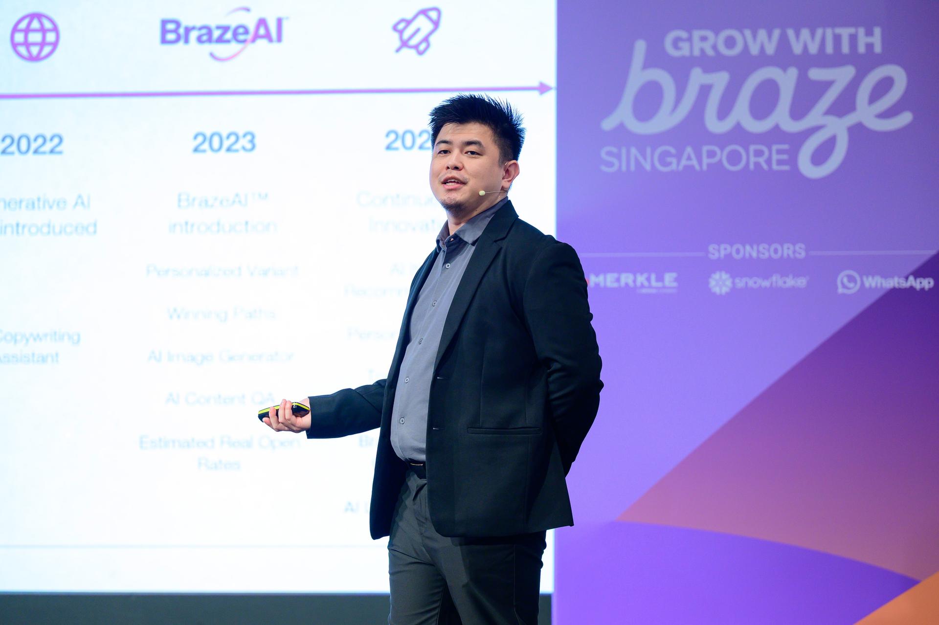 a man in a suit is giving a presentation in front of a large screen .