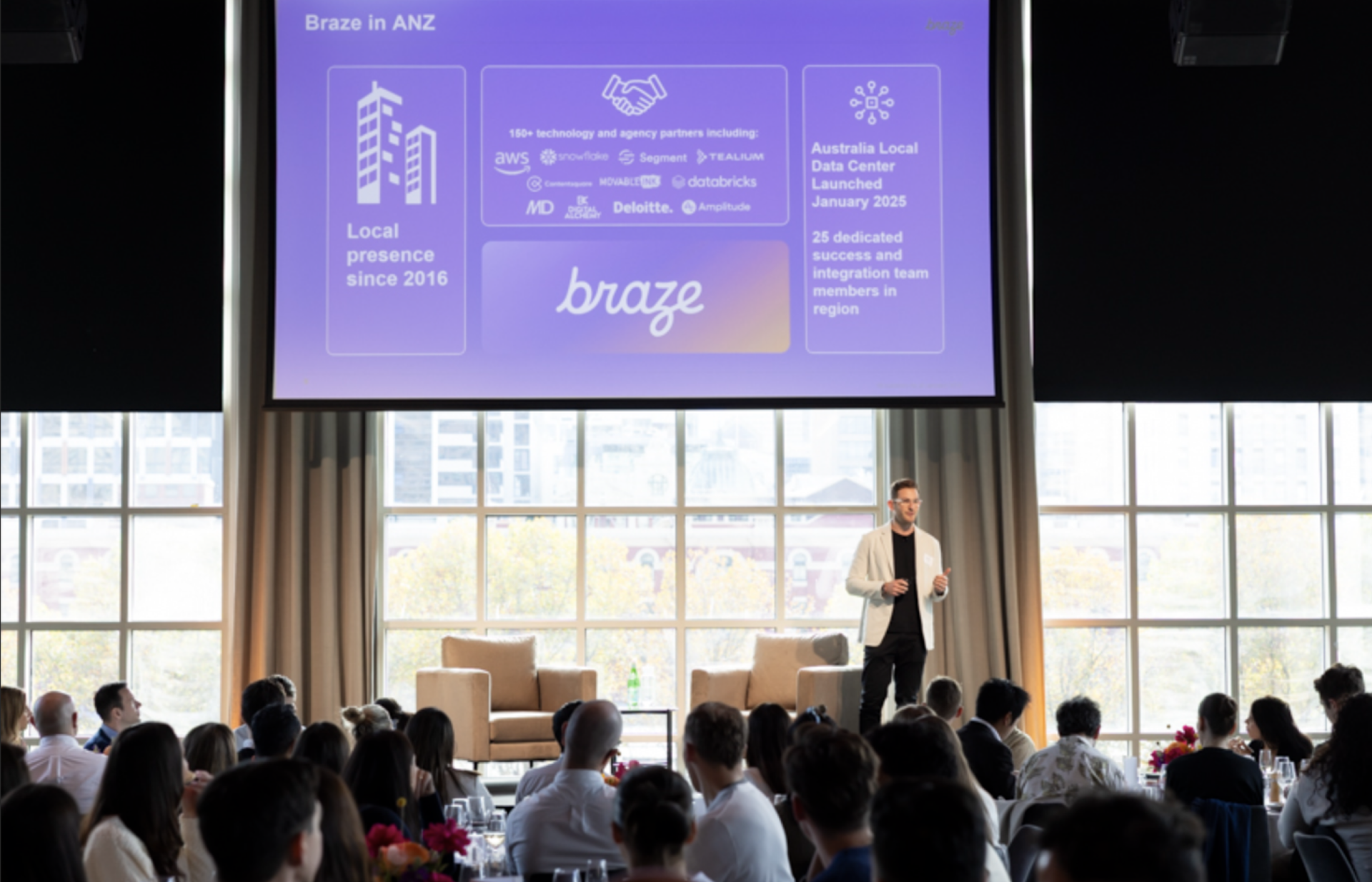 a man stands in front of a screen that says braze in anz
