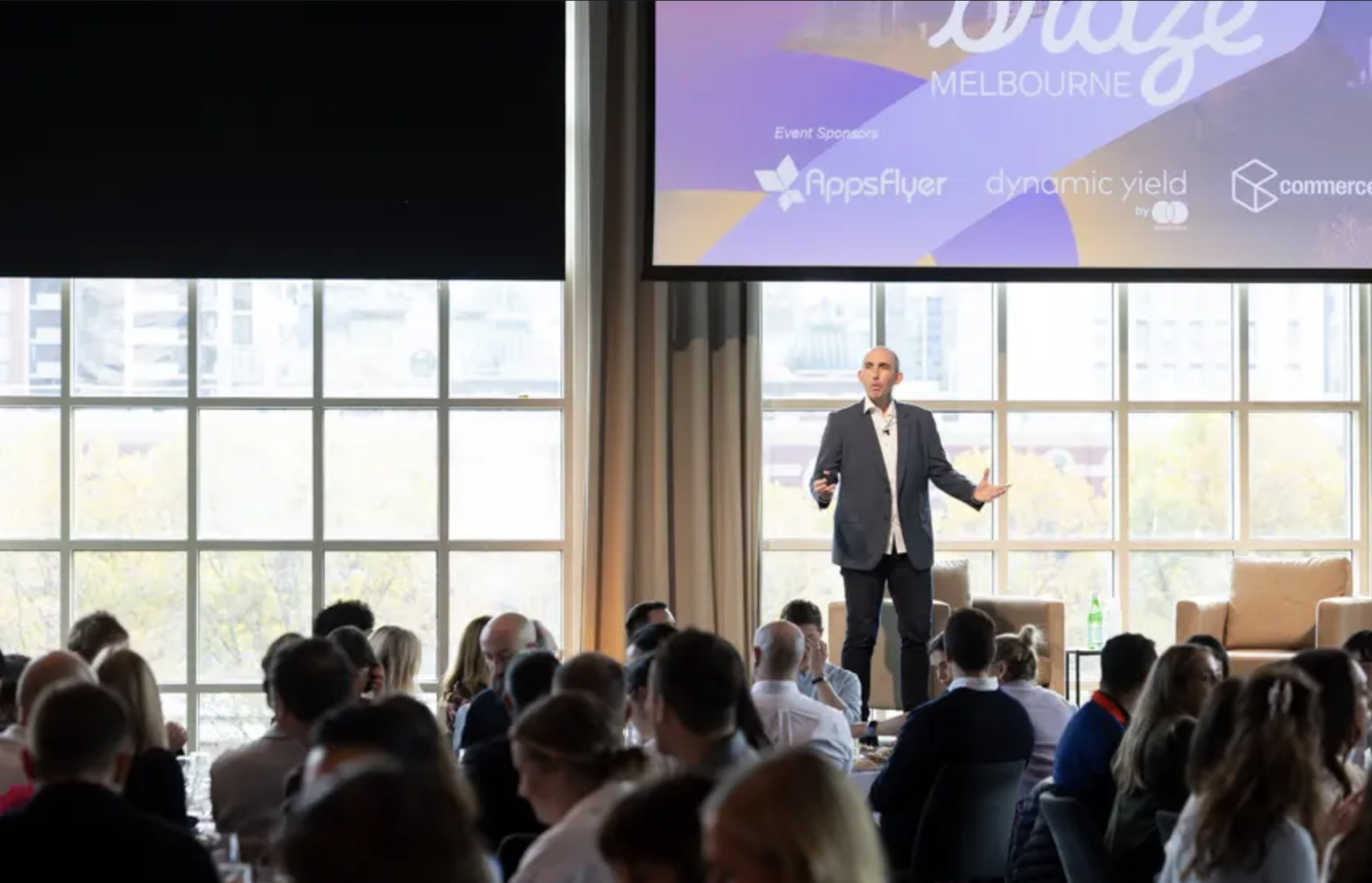 a man stands in front of a screen that says melbourne on it