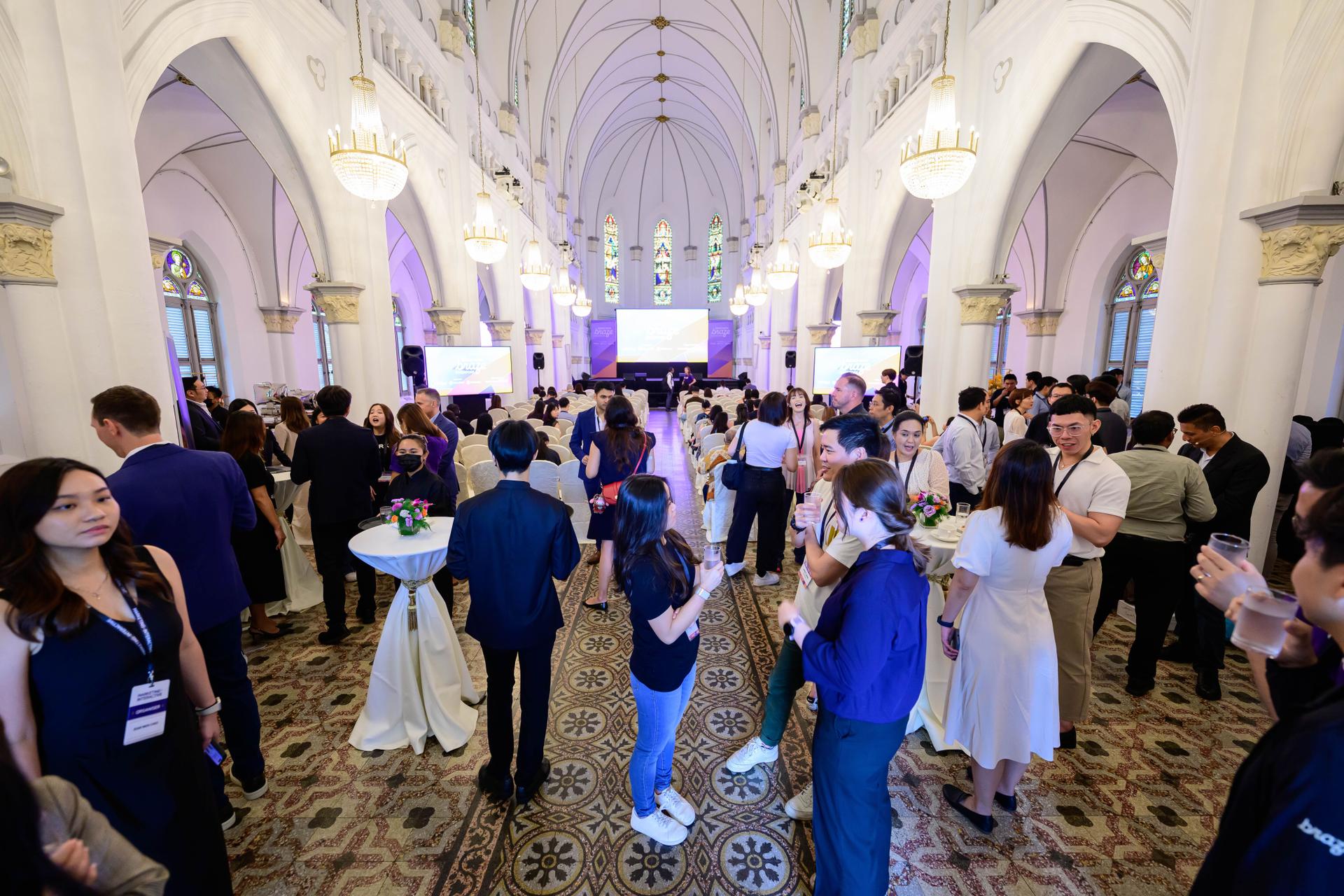 a large group of people are standing in a large room .