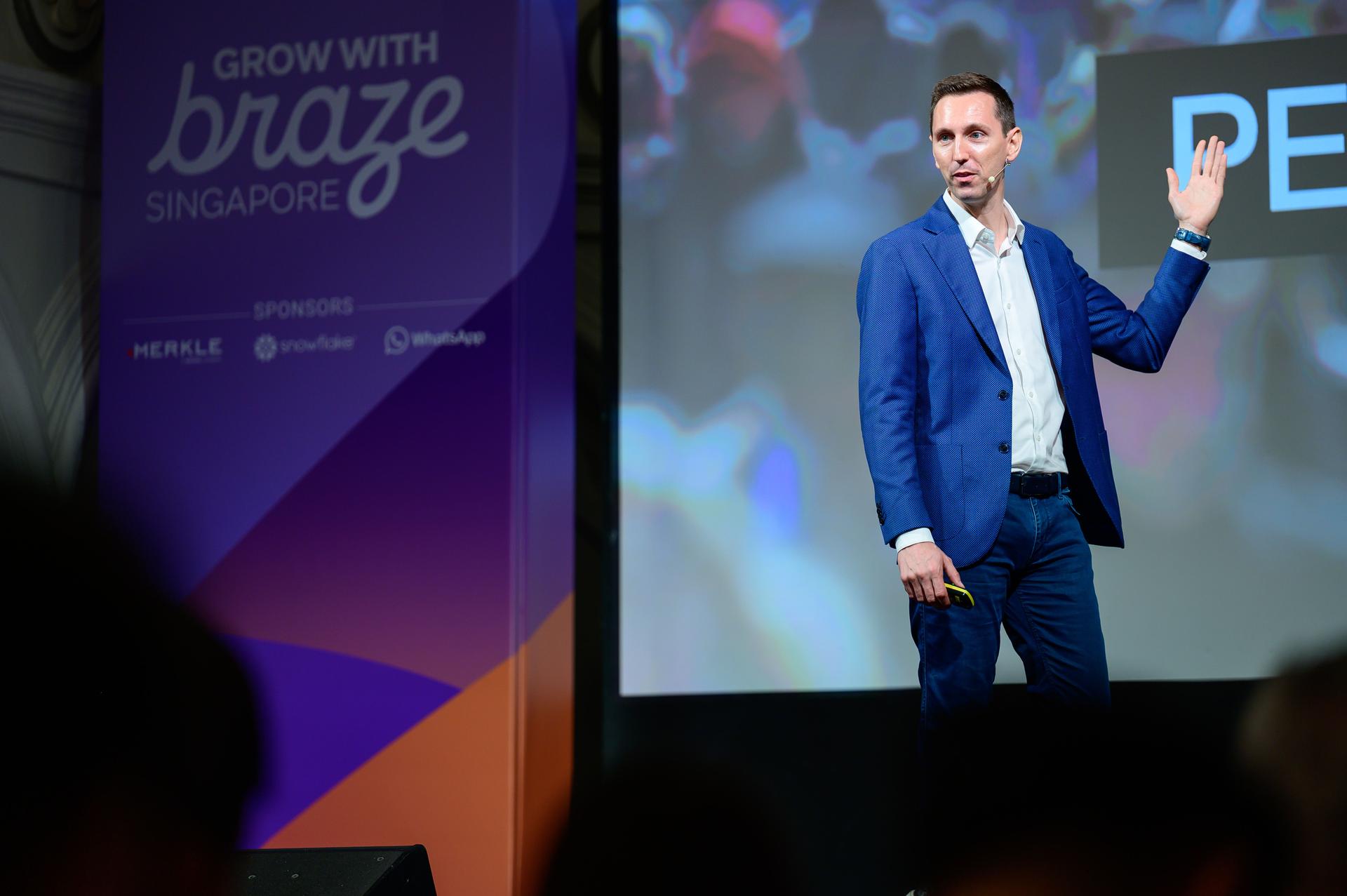 a man in a suit is standing on a stage giving a speech .