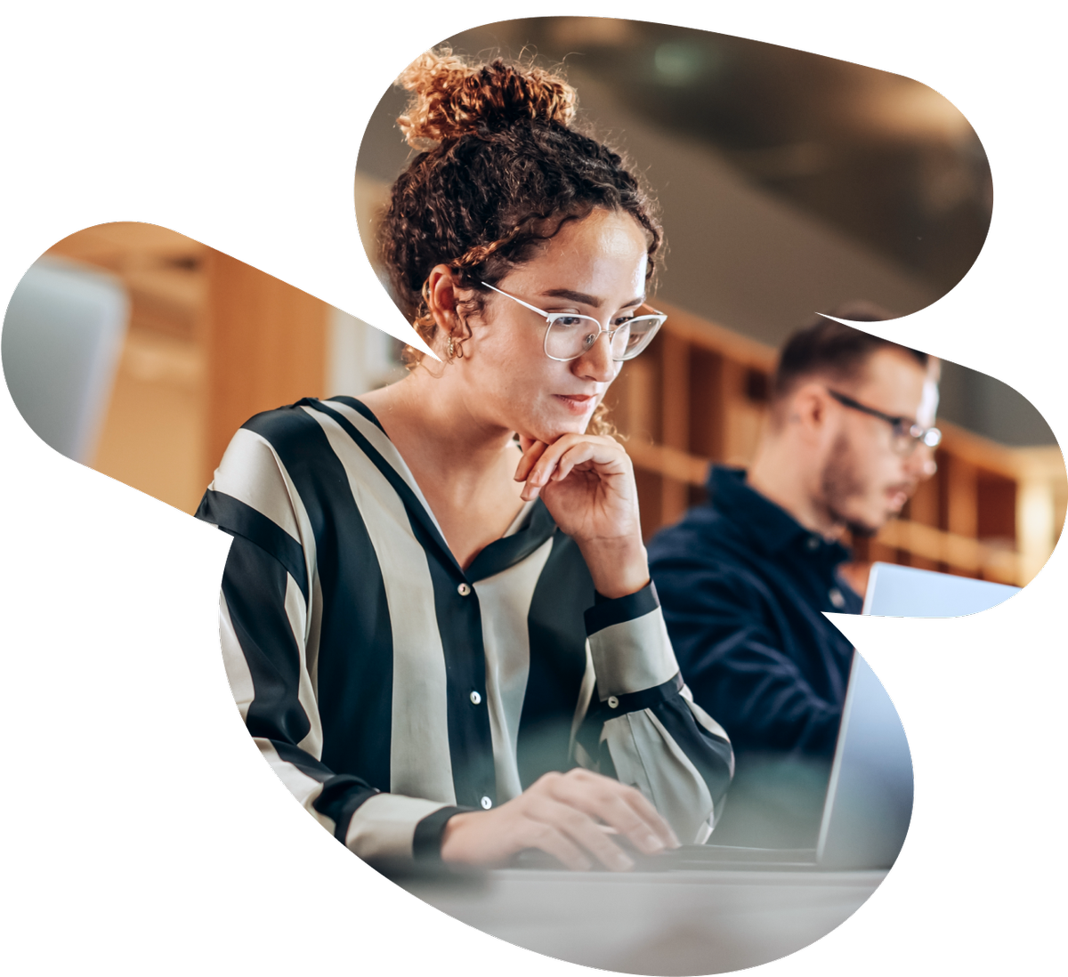 a woman wearing glasses is typing on a laptop