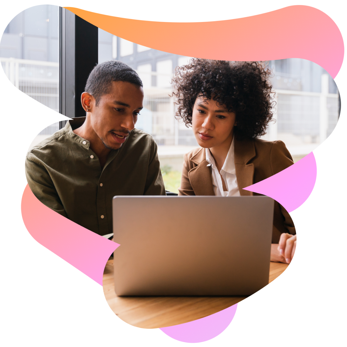 a man and a woman are looking at a laptop together